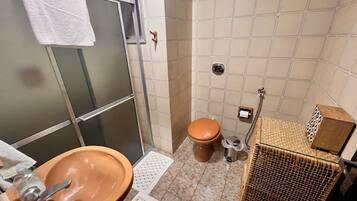 Chuveiro, toalhas de banho, sabonete, papel higiênico