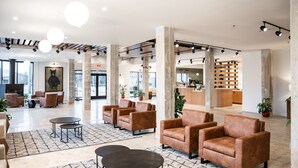 A spacious lobby with leather armchairs, a coffee bar, and a large painting of a bear. - Bridge Creek Inn (Clayton)