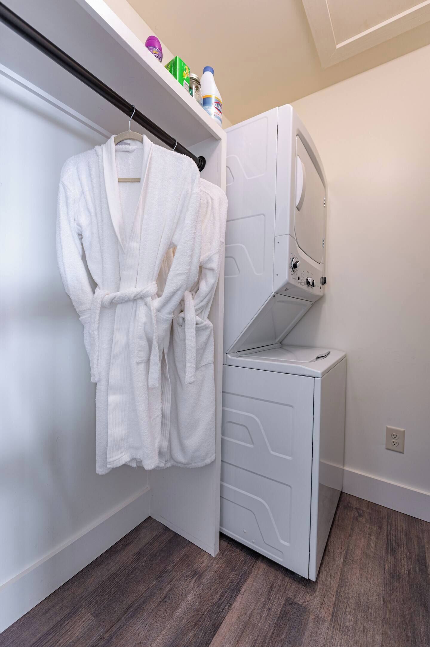 A compact laundry room with a white washing machine and a drying rack.