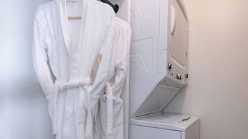 Een kleine wasruimte met een witte wasmachine en een droogrek.