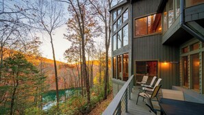 Ein modernes Haus mit Terrasse mit Blick auf ein bewaldetes Gebiet.