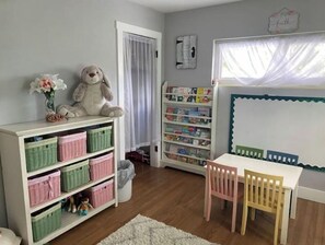 A child's room with a bookshelf, a small table, and a chair. - Beautiful Coastal Beach Home - 2 min walk to Beach- 4 bedroom 3 bath 2 masters!
(Neptune Beach)