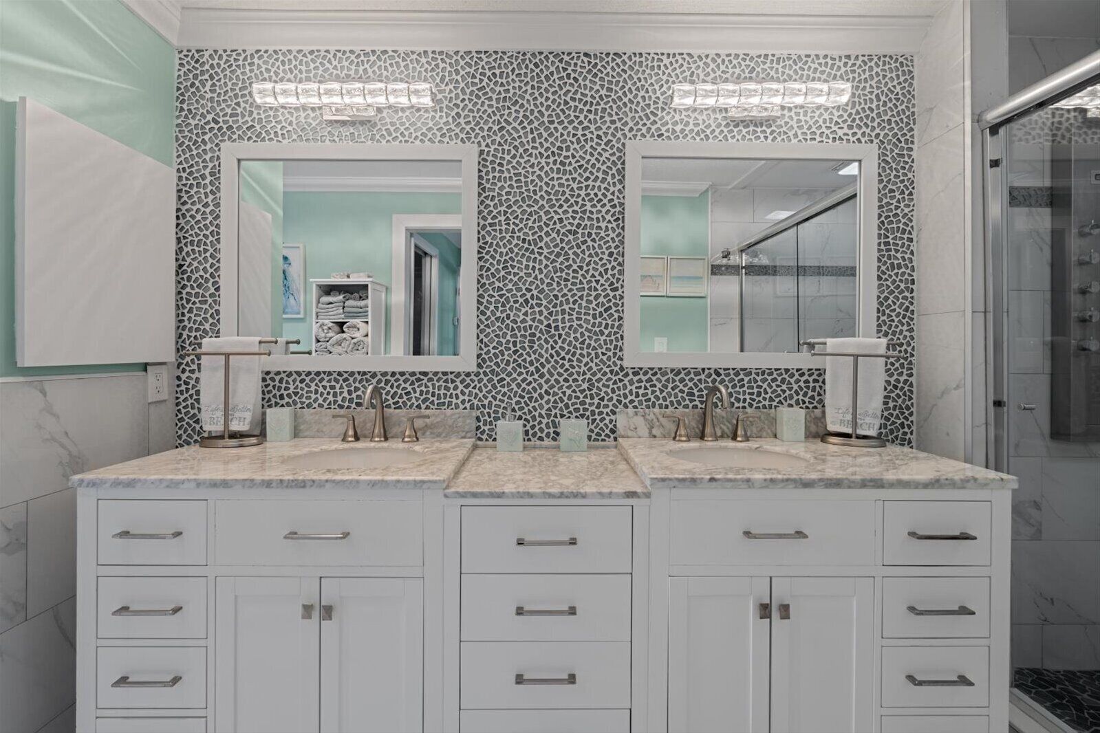 A bathroom with a double vanity, two sinks, and a shower.