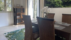 A dining area with wicker chairs, a table with placemats, and a vase with white flowers. - Diano Marino / Rollo 100sqm 4 pers. quiet with sea view (Andora)