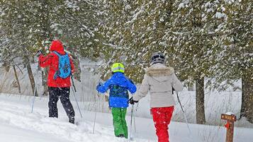 Un sendero nevado con tres personas caminando.