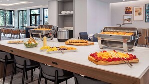 Ein reichhaltiges Buffet mit verschiedenen Speisen und einer Kaffeestation.