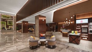 Eine großzügige Lobby mit hoher Decke, moderner Einrichtung und einer zentralen Sitzecke.