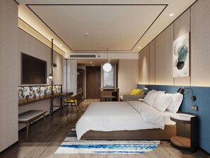 A modern hotel room with a large bed, a desk, a chair, a TV, and a bathroom. - Hilton Garden Inn Nantong Rudong (Nantong)