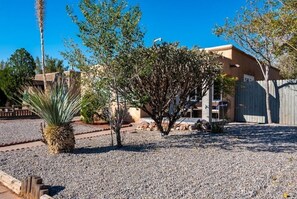 Enjoy the serene atmosphere of this single-family home surrounded by a well-maintained lawn and lush trees.