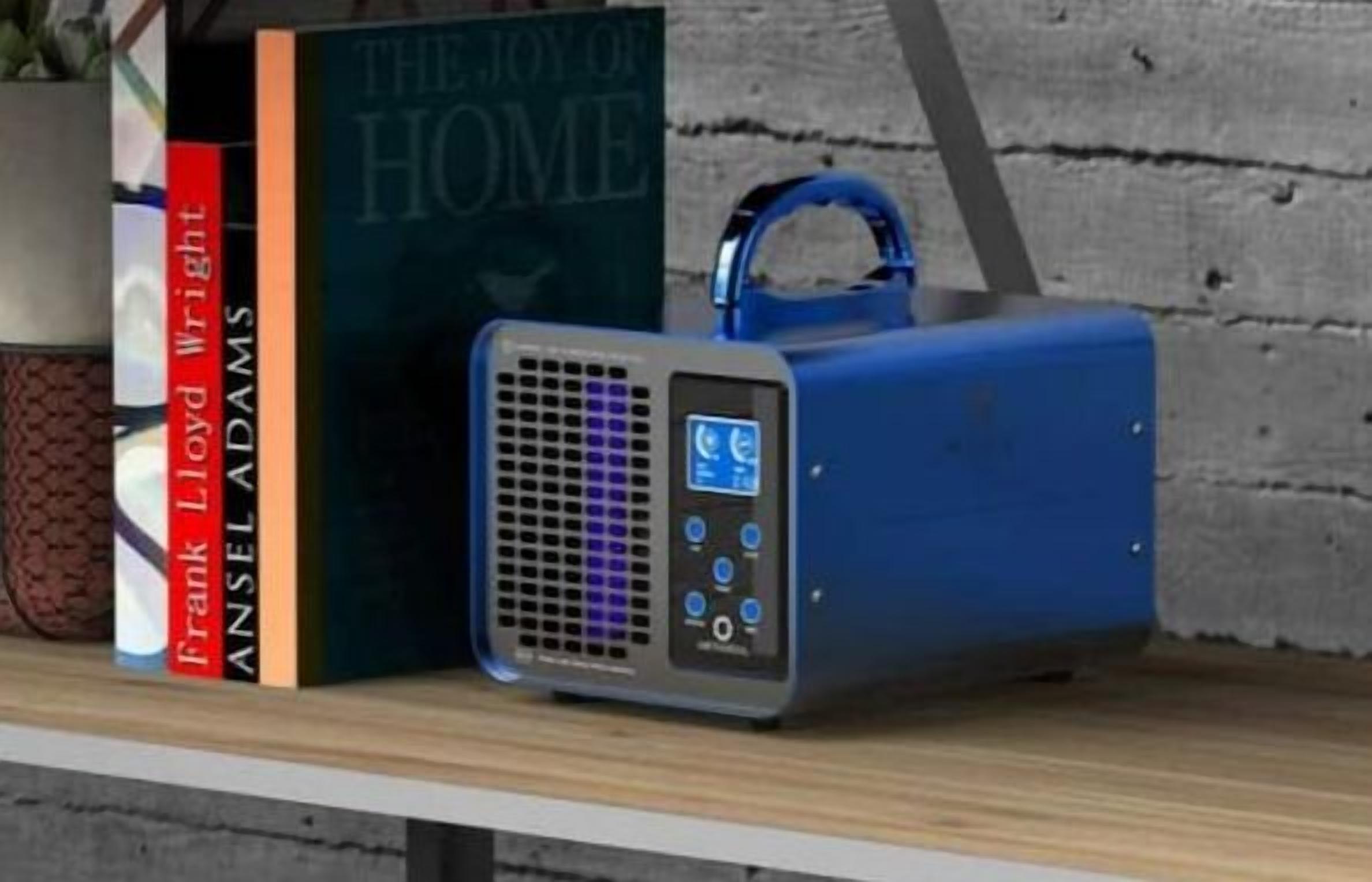 A bookshelf with books and a portable speaker.