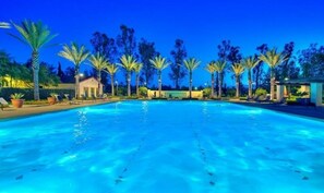 A swimming pool with clear blue water, surrounded by palm trees and lounge chairs. - Exquisite 4-bedroom and 4b villa  Irvine eastwood (Irvine)