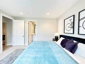 A bedroom with a bed, a nightstand, a lamp, and two framed pictures on the wall. - Exquisite 4-bedroom and 4b villa  Irvine eastwood (Irvine)