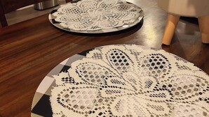A dining table with two lace placemats, a potted plant, and a wooden chair. - Spacious Home Base with Private Office—Perfect for Remote Work (Lake Charles)