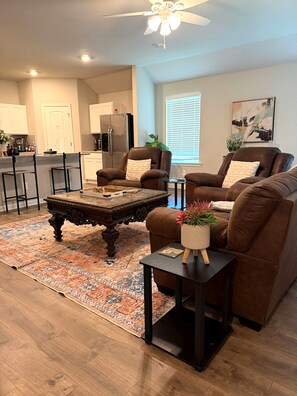 A modern living room with a coffee table, two sofas, and a rug. - Spacious Home Base with Private Office—Perfect for Remote Work (Lake Charles)