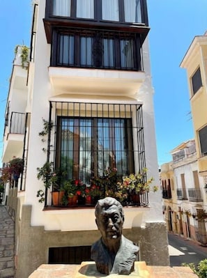 Um edifício moderno com uma estátua em frente.