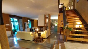 A spacious living area with a sofa, a coffee table, and a decorative elephant statue. A staircase with wooden steps leads to an upper floor. - La Villa de Palacios (Voto)