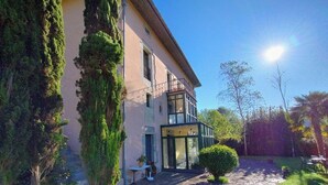 A two-story building with a stone pathway leading to a glass entrance. - La Villa de Palacios (Voto)