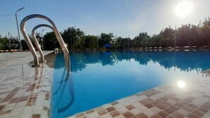 A swimming pool with a tiled edge and a metal diving board. - Green Apple Hotel (Tashkent)
