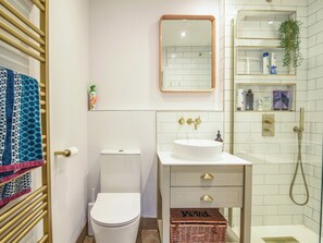 A bathroom with a toilet, sink, and shower. - Coastal View (Lyme Regis)