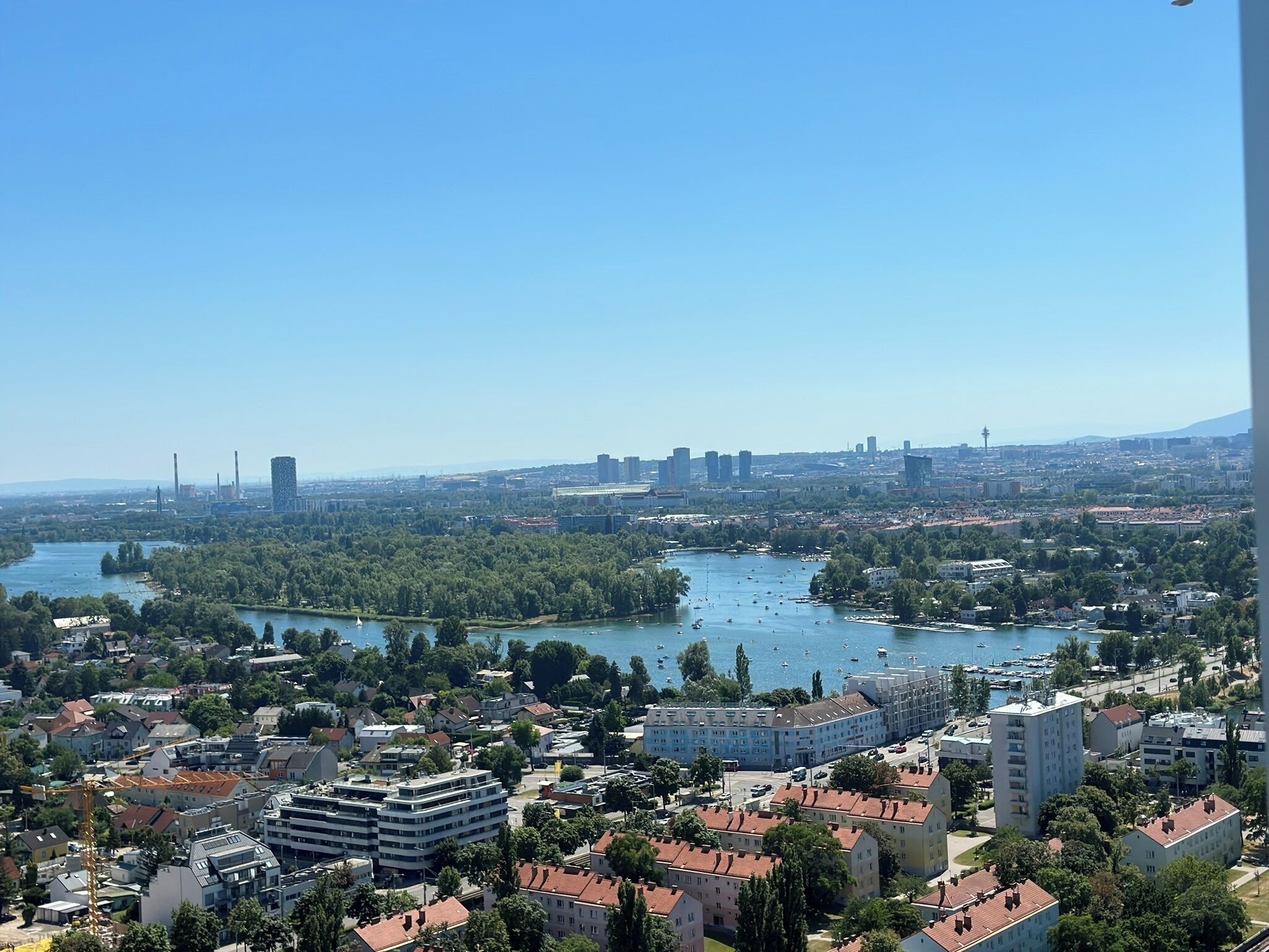 A cityscape with a river, residential buildings, and a distant city skyline.