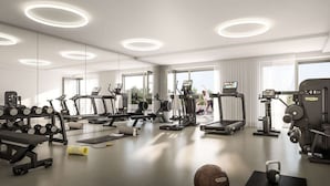 A modern gym with various exercise equipment, including treadmills, elliptical machines, and free weights. - Green High-end Apartment Close to Metro, Uno-city, E-parking, Pool, Gym, Sauna (Vienna)