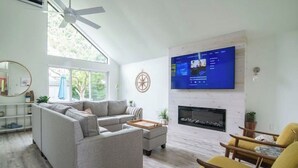 A modern living room with a sofa, armchair, and fireplace. - Delightful & Modern seaside escape/Handicap Access (New London)