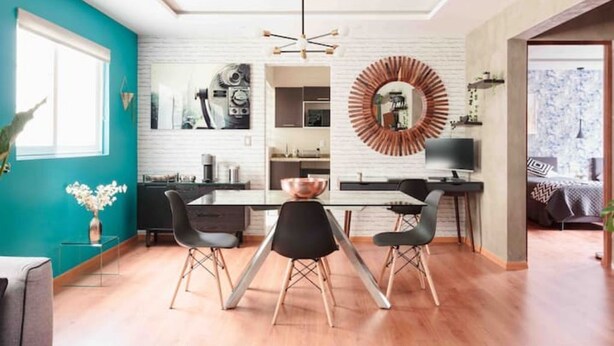 A modern kitchen with a white brick backsplash, a central island, and black chairs. - Designful Apartment in Trendy Roma Norte/Condesa (Ciudad de México)