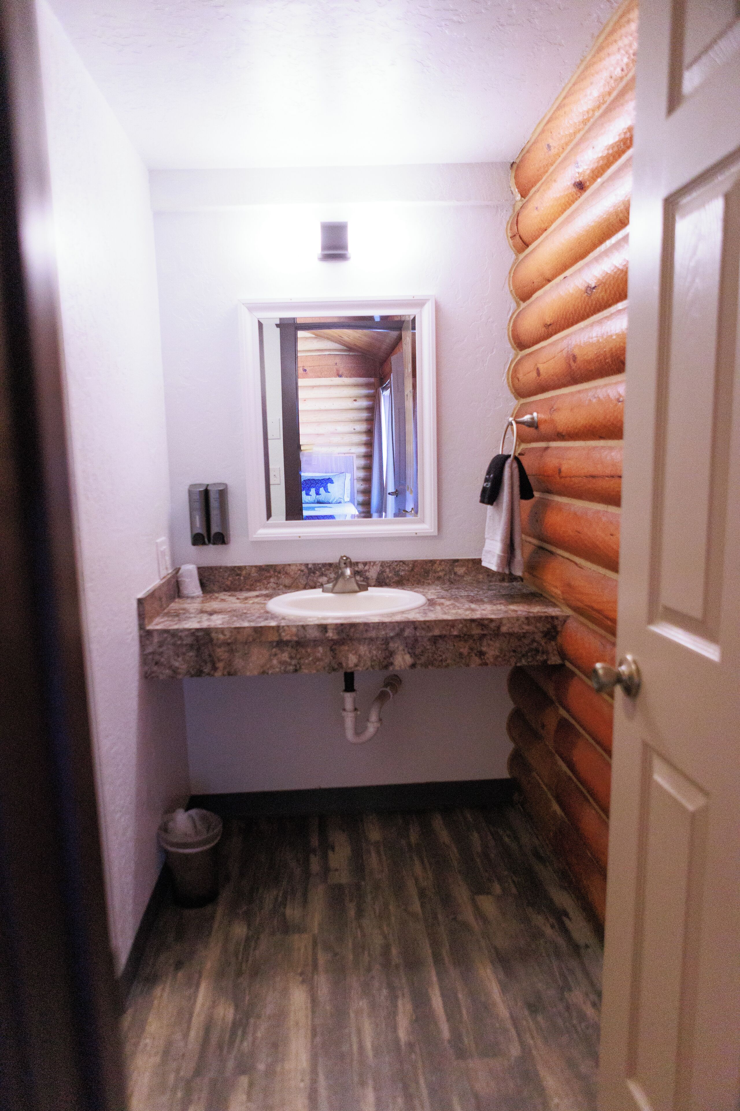 A bathroom with a wooden wall, a sink, and a window.