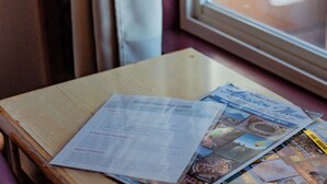A wooden table with a menu and brochures. - Big Medicine Cabins (St. Ignatius)