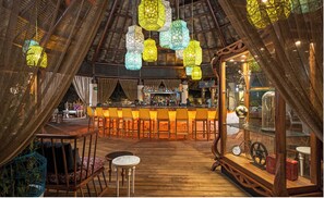 Relax in this inviting space with a high ceiling, central bar, and rustic charm.