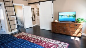 A bedroom with a bed, a dresser, a TV, a ladder, a closet, and a view of a lake. - Beautifully restored home in Butler Tarkington Walking Distance to Butler Campus (Indianapolis)