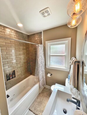A bathroom with a bathtub, shower, and sink. - Beautifully restored home in Butler Tarkington Walking Distance to Butler Campus (Indianapolis)