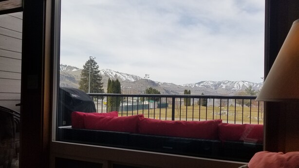 Ein Zimmer mit großem Fenster und Blick auf eine verschneite Berglandschaft.