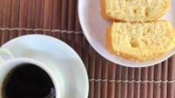 Una taza de café blanco sobre una estera de bambú.