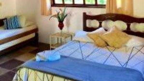 Une chambre à coucher avec un lit, une table de chevet et une fenêtre.
