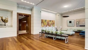 A spacious lobby with wooden flooring, a reception desk, seating area, and artwork on the walls. - ARYA HOTEL STUDIO OCEAN VIEW BALCONY FREE PARKING (Miami)