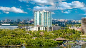 A waterfront hotel with multiple balconies, a marina with boats, and a cityscape in the background. - ARYA HOTEL STUDIO OCEAN VIEW BALCONY FREE PARKING (Miami)