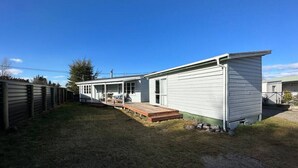 A single-story mobile home with a covered porch and a small deck. - Bach Bliss, Twizel. Free Wifi. (Twizel)
