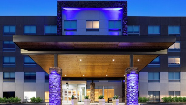 A modern hotel with a flat roof, large windows, and a covered entrance area with stone pillars. - Holiday Inn Express & Suites Waynesboro East by IHG (Waynesboro)