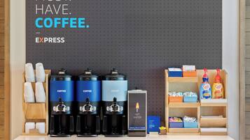 Una estación de café con tres dispensadores de café, un dispensador de agua caliente y un molinillo.
