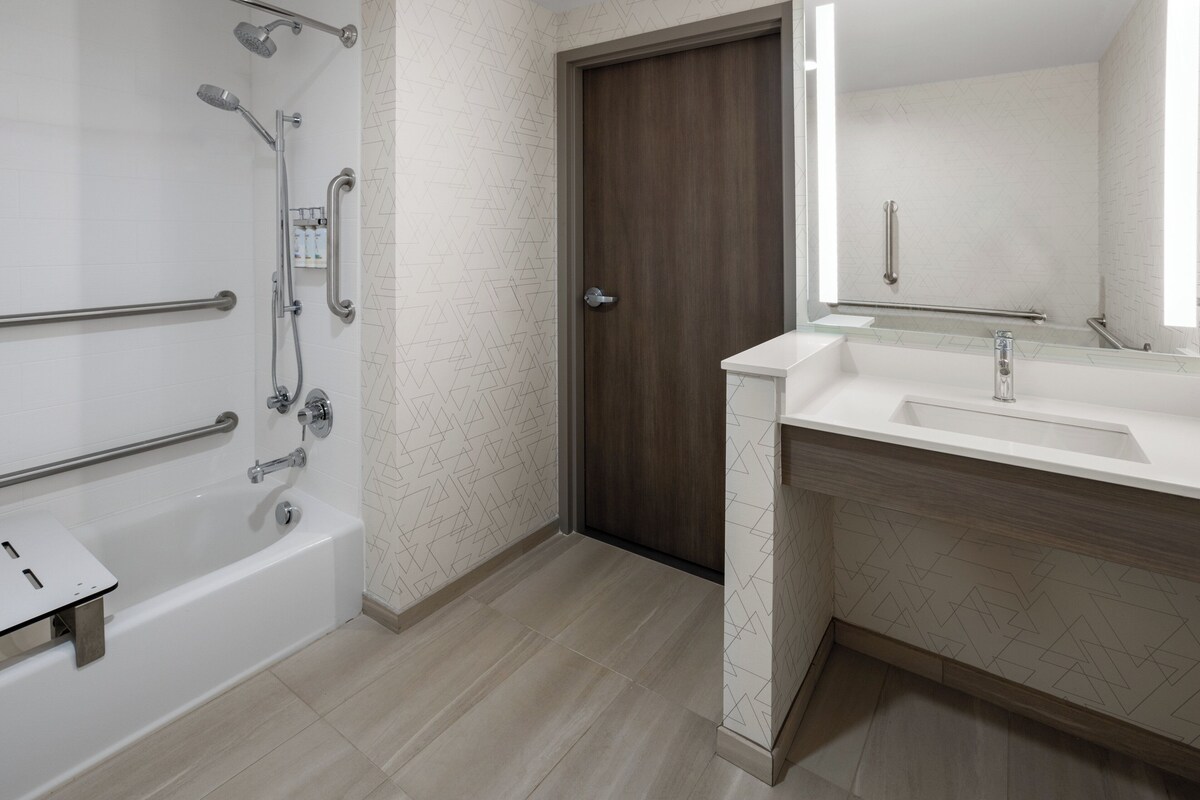 Une salle de bain moderne avec une baignoire, une douche et un meuble-lavabo.