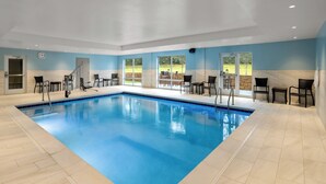 An indoor swimming pool with clear blue water, surrounded by chairs and a view of the outdoors. - Holiday Inn Express & Suites Waynesboro East by IHG (Waynesboro)