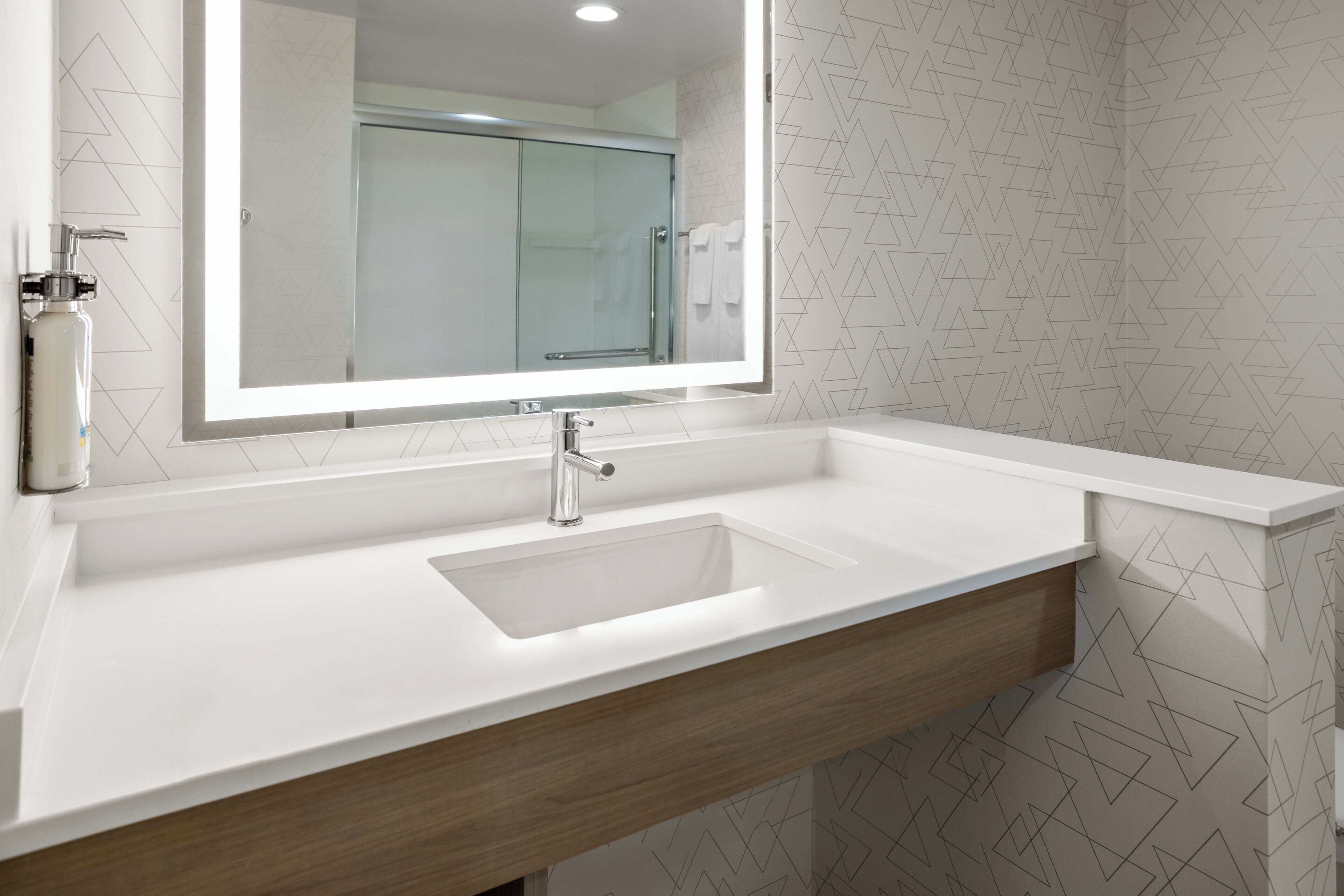 Une salle de bain moderne avec un lavabo blanc, un miroir et un meuble-lavabo en bois.