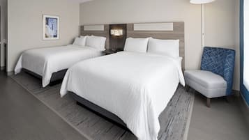 Een hotelkamer met twee bedden, een nachtkastje, een lamp en een stoel.