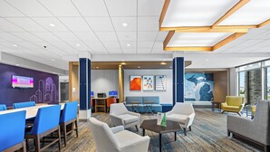 A hotel lobby with a seating area, a reception desk, and a large window offering a view. - Holiday Inn Express & Suites Marinette by IHG (Marinette)