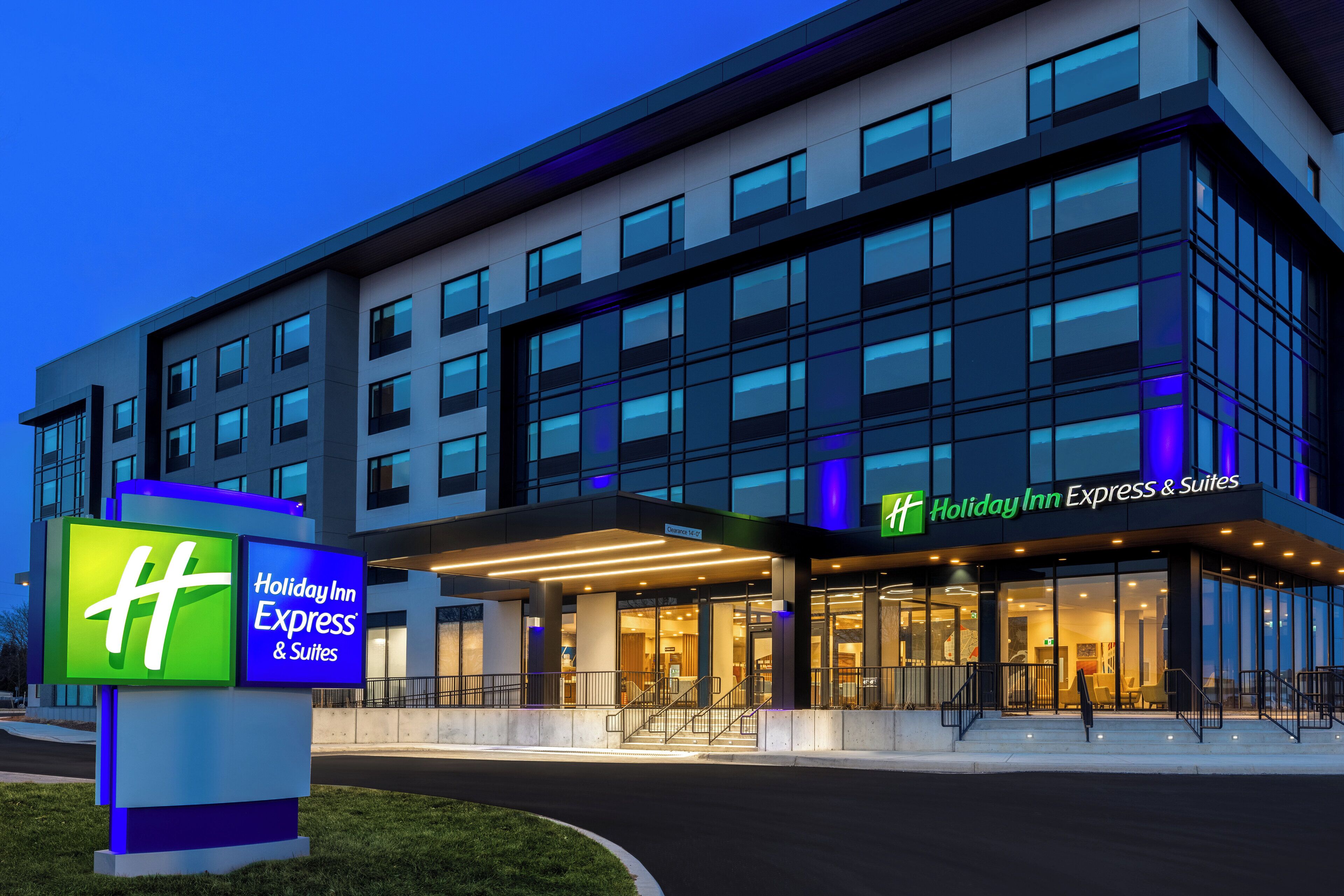 A Holiday Inn Express & Suites building with a modern design, large windows, and a prominent sign.