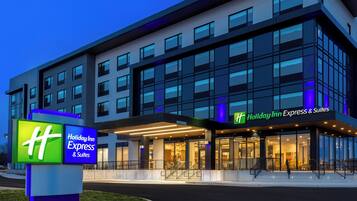 Edificio de Holiday Inn Express & Suites con diseño moderno, ventanas amplias y un cartel llamativo.