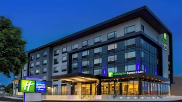Edificio de Holiday Inn Express & Suites con un diseño moderno, ventanas amplias y una entrada bien iluminada.
