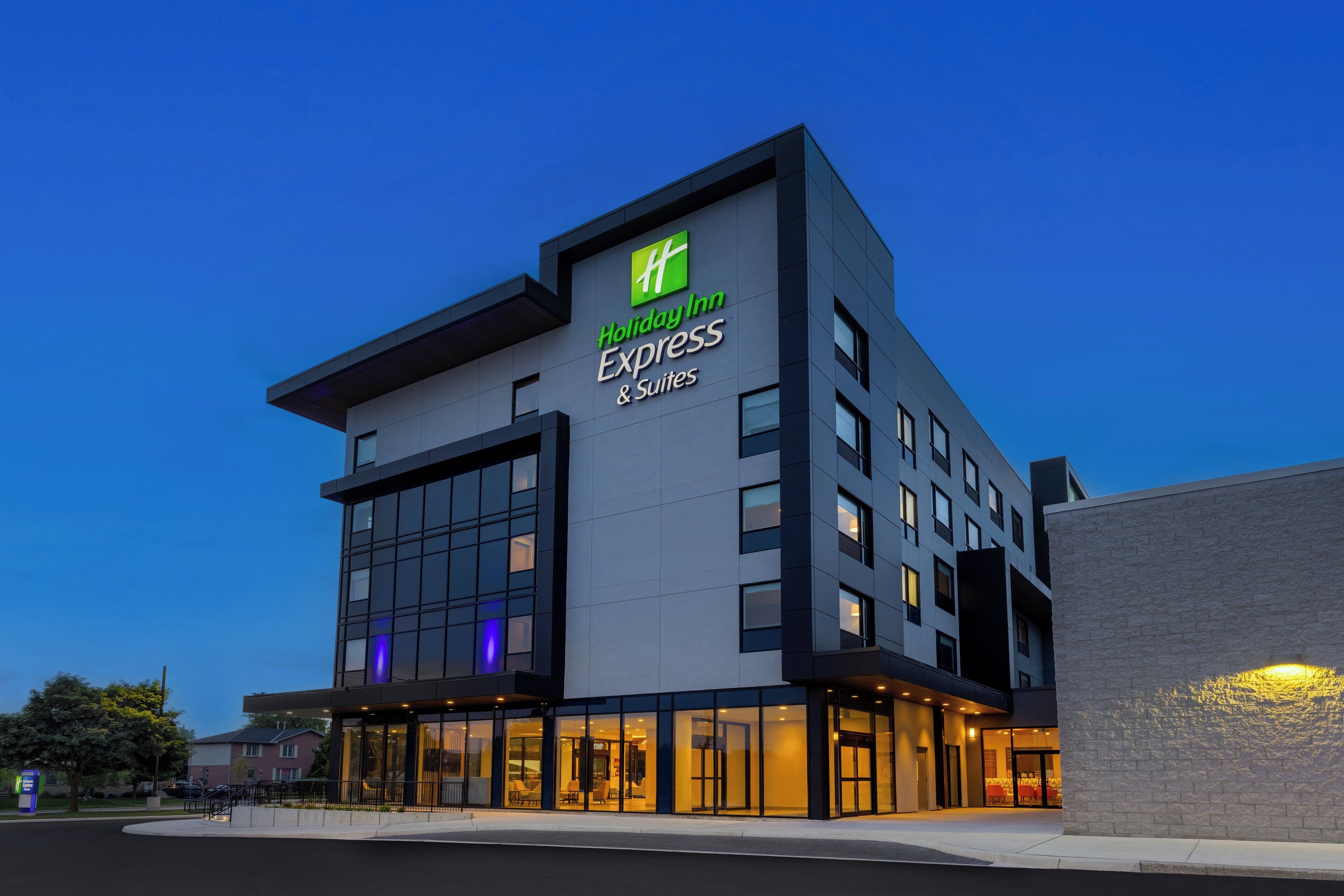 A Holiday Inn Express & Suites building with a modern design, large windows, and a prominent sign.