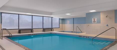 A swimming pool with clear depth markers, a sunroof, and a tiled floor.